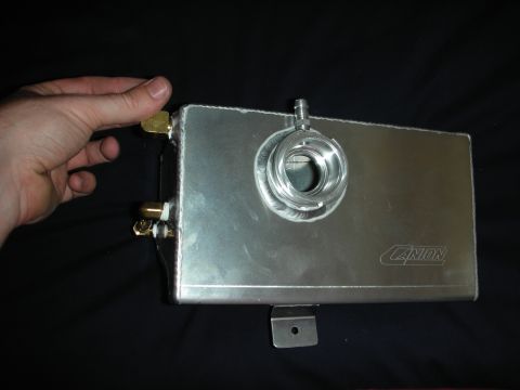 1998 Ford Crown Victoria - A hand is shown holding an aluminum coolant overflow tank with a "CANON" logo etched on its side.