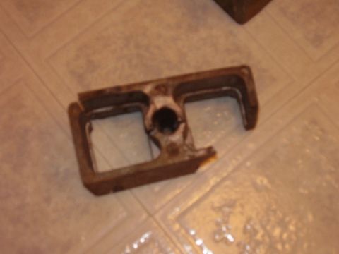 2000 Chevrolet Tahoe - A close-up view of a single, rusted metal component resting on a tiled surface.