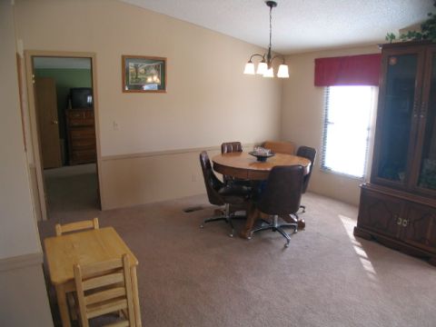 1995 Ford Bronco - A view of a dining area a round table with chairs, a large cabinet, and a hallway leading to another room.