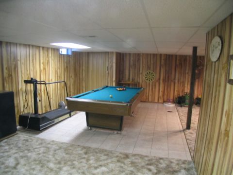 1995 Ford Bronco - Recreation room in basement features a pool table, treadmill, and dartboard.