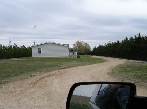 1995 Ford Bronco - View from vehicle shows a rural property with a house and winding driveway.