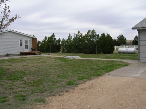 1995 Ford Bronco - Yard scene includes a house, trees, and a large propane tank under an overcast sky.