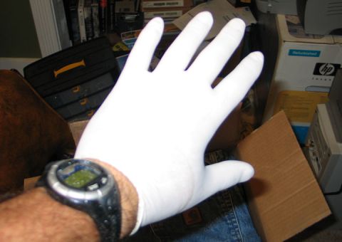 1994 Ford Bronco - Hand wearing a white glove and a digital watch is shown against a cluttered background.