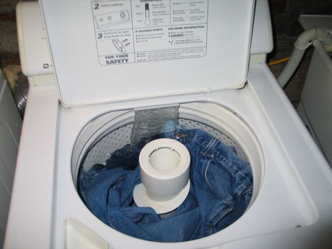 1994 Ford Bronco - Jeans are being washed inside a top-loading washing machine.