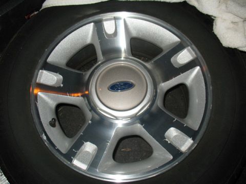 1997 Ford Crown Victoria - Ford alloy wheel shown up close, with a black tire surrounding it.