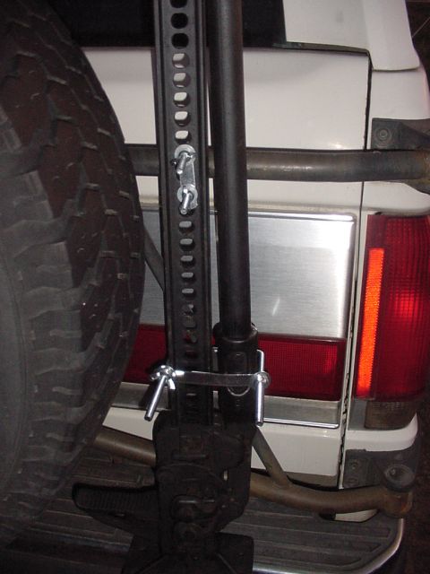 1988 Ford Bronco — Rear view of white SUV with hi-lift jack attached to spare tire carrier