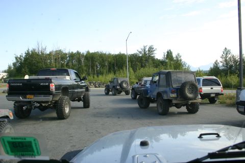 2003 Jeep TJ - A group of off-road vehicles are gathered in a parking area on a clear day.
