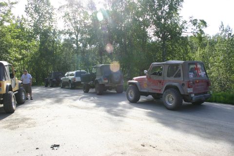2003 Jeep TJ - A group of off-road vehicles are lined up on a dirt road, ready for an adventure.
