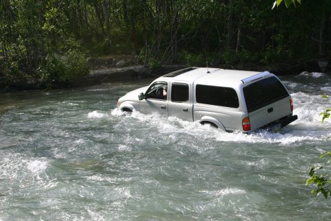 2003 Jeep TJ - Toyota Tacoma pickup truck navigates a river crossing.
