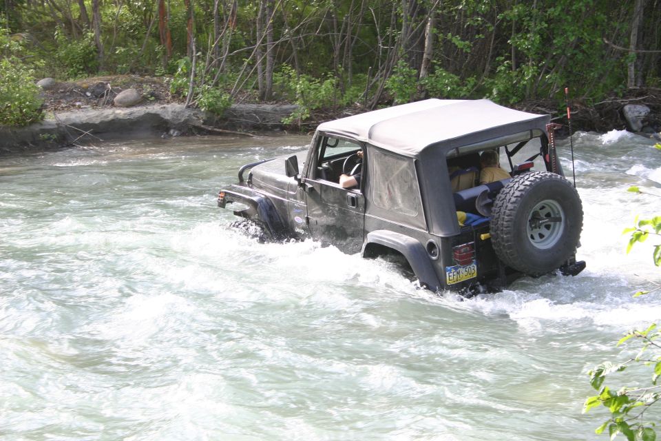 Black 2003 Jeep TJ driving through river rapids
