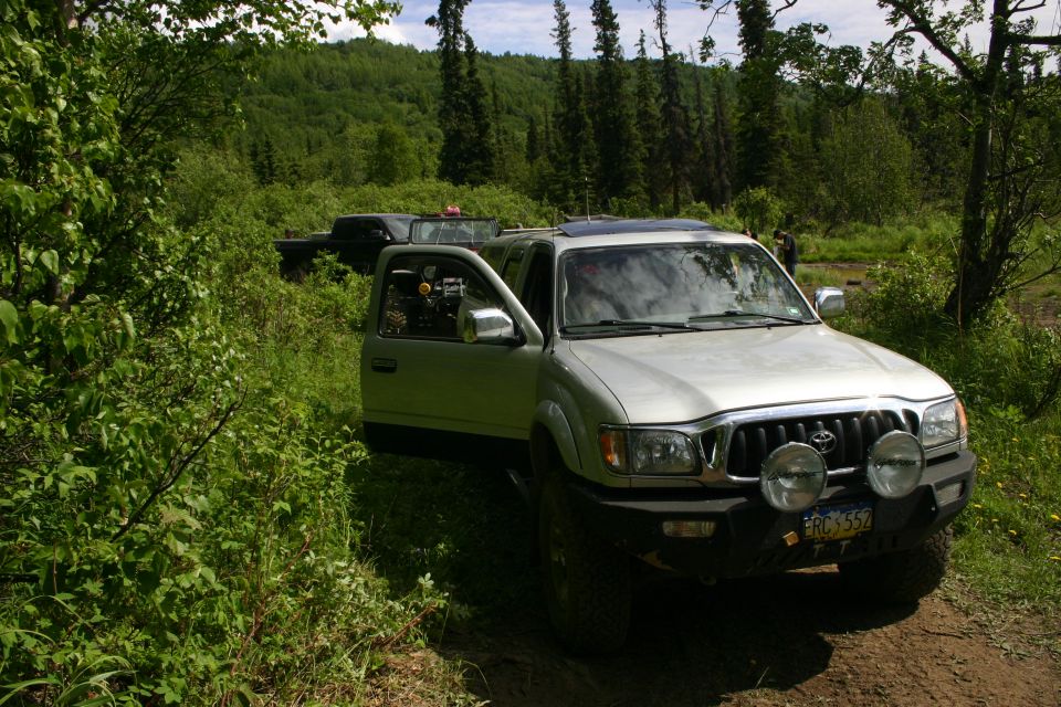 Silver 2003 Toyota Tacoma with off-road lights and open driver door