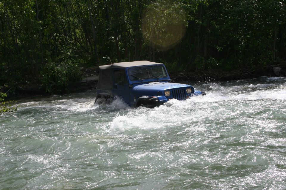 Blue Jeep Wrangler driving through a river. This is a 2003 Jeep TJ