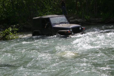2003 Jeep TJ - Jeep TJ navigates a rocky river crossing, demonstrating off-road capability.