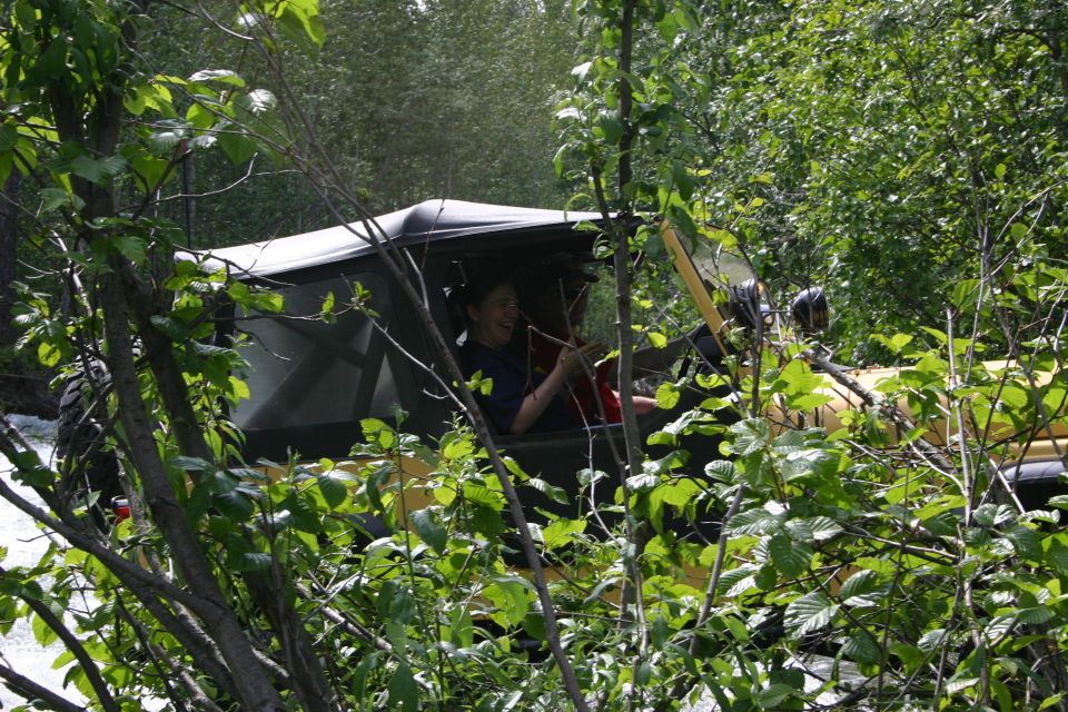 Yellow 2003 Jeep TJ with driver visible through foliage