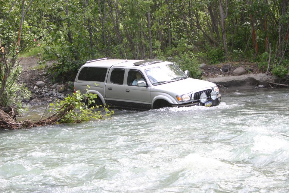 Silver 2003 Toyota Tacoma driving through river