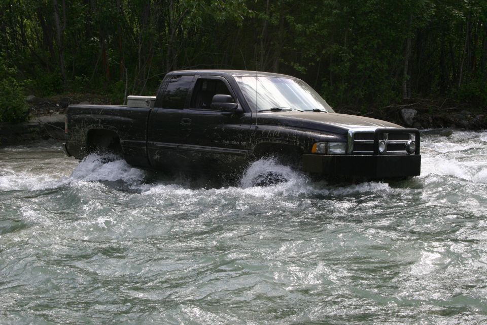 Black pickup truck fording a river, front view