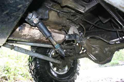 2003 Jeep TJ - The muddy undercarriage of an off-road vehicle, highlighting the steering and suspension components.