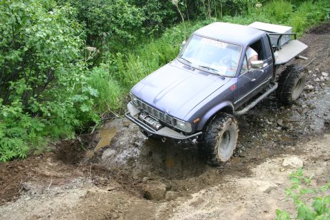 2003 Jeep TJ - This modified pickup truck navigates a challenging muddy off-road course.