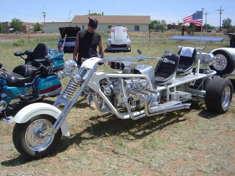 1986 Ford Bronco II - A custom-built white trike with a V8 engine is displayed outdoors next to a motorcycle and other vehicles.
