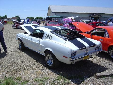 1986 Ford Bronco II - White 1967 Ford Mustang fastback with black racing stripes and rear window louvers.