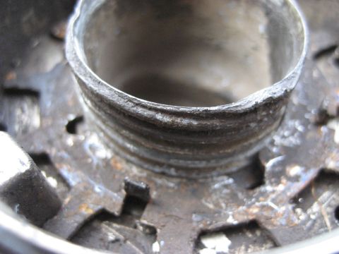 1991 Ford Bronco - Close-up of a rusty metal hub with threaded interior and visible gear teeth, likely a Warn Premium hub.