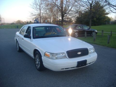 2003 Ford Crown Victoria - White 2003 Ford Crown Victoria parked outside with a dark car in the background.