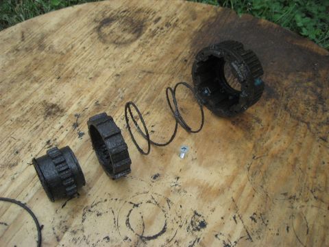 1991 Ford Bronco - Disassembled Warn Premium hubs, including springs and a screw, are laid out on a wooden surface.