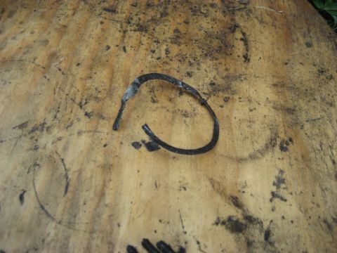 1991 Ford Bronco - A damaged rubber hose lies on a weathered wooden surface, showing signs of wear and tear.