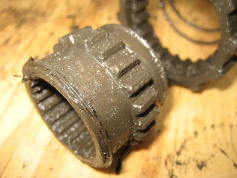 1991 Ford Bronco - Close-up of a greasy metal hub part with visible teeth, resting on a wooden surface.