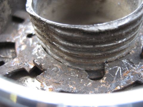 1991 Ford Bronco - This is a close-up view of a rusty Warn Premium hub, showing its threaded interior and mounting hardware.