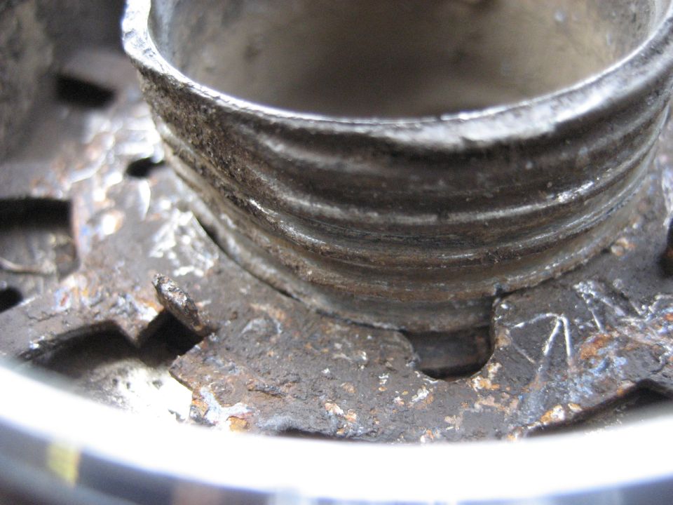Close-up of a rusty Warn Premium hub with visible threads and mounting points. Supermotors.net logo visible at bottom right