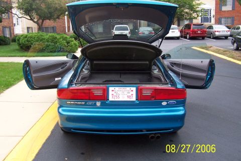 1994 Ford Probe - Rear view of a blue coupe with its trunk and doors open, showing the interior and cargo space.