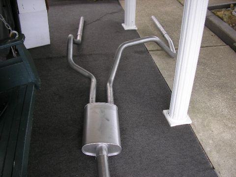 1994 Ford Probe - A dual exhaust system is laid out on a dark carpeted surface.