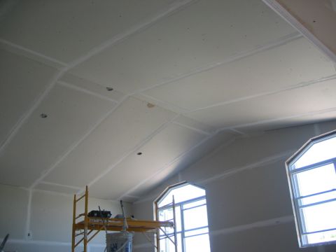 1984 Ford Bronco - Interior view of a room under construction, showing unfinished drywall and scaffolding.