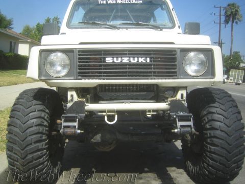 1987 Suzuki Samurai - Front view of a modified 1987 Suzuki Samurai oversized tires and a custom bumper.