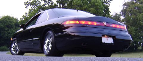 1996 Mercury Grand Marquis - Rear view of a black 1996 Mercury Grand Marquis coupe with chrome wheels parked outdoors.
