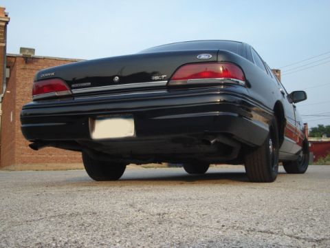 1992 Ford Crown Victoria - The rear of a black 1992 Ford Crown Victoria is shown from a low angle.