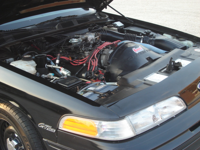 Engine bay of a 1992 Ford Crown Victoria, showing the V8 engine, battery, and air intake