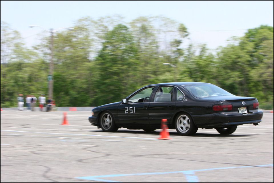 Black sedan with racing number 251 on its side, viewed from the side at an autocross event