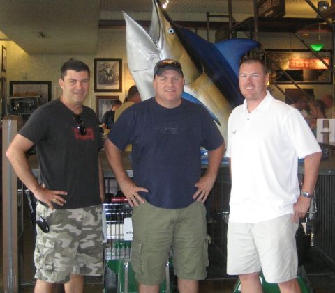 1986 Ford Bronco - Three men pose for a photo in front of a large marlin display at a restaurant.