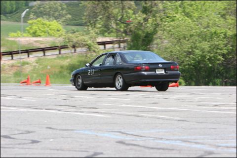 2001 Mercury Grand Marquis - A black sedan with racing number 251 is seen on a race track, navigating around orange cones.