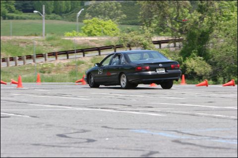 2001 Mercury Grand Marquis - Black sedan navigates a course marked by orange cones on a paved track.