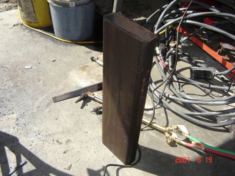 1993 Ford Bronco - A metal pipe and welding equipment are laid out on a concrete surface, with two buckets in the background.