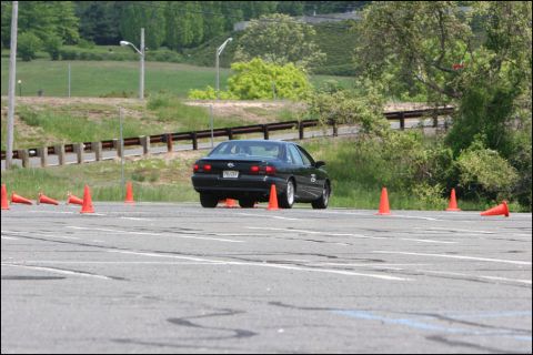 2001 Mercury Grand Marquis - A black sedan is shown on an asphalt course marked with orange cones, likely during a timed event.