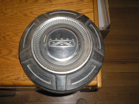 1989 Ford F-250 - A single metal hubcap is shown, with visible scratches and a prominent emblem in the center.