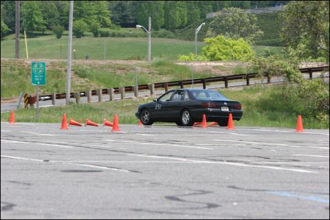 2001 Mercury Grand Marquis - A black sedan navigates a course marked by orange cones on a paved surface.