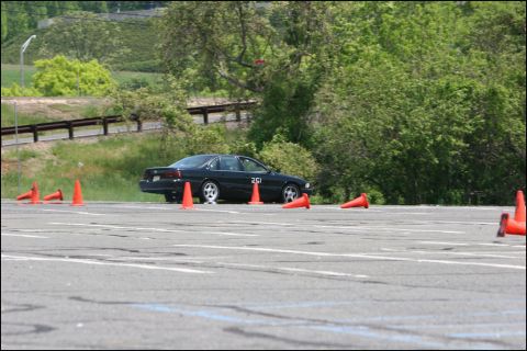 2001 Mercury Grand Marquis - A black sedan is positioned on a track with orange cones, suggesting a driving event or practice.