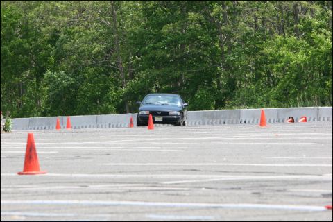 2001 Mercury Grand Marquis - A dark sedan is seen on a race track, maneuvering around orange cones during an event.