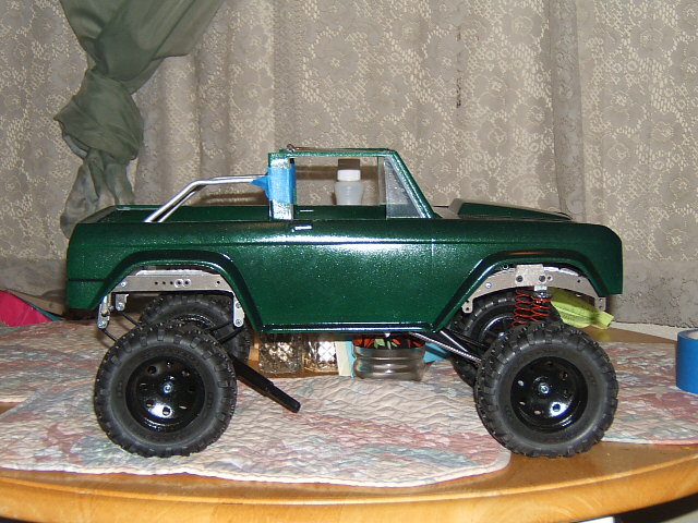 Green RC crawler model with off-road tires and visible suspension components