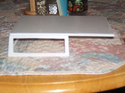 1988 Ford Bronco - A white foam model with a rectangular cutout sits on a patterned cloth, possibly a display stand.